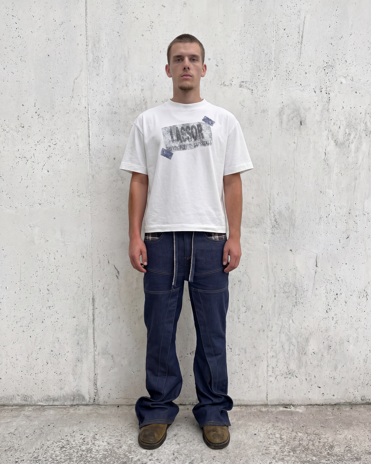 Modelo con vaqueros raw denim flared y camiseta blanca