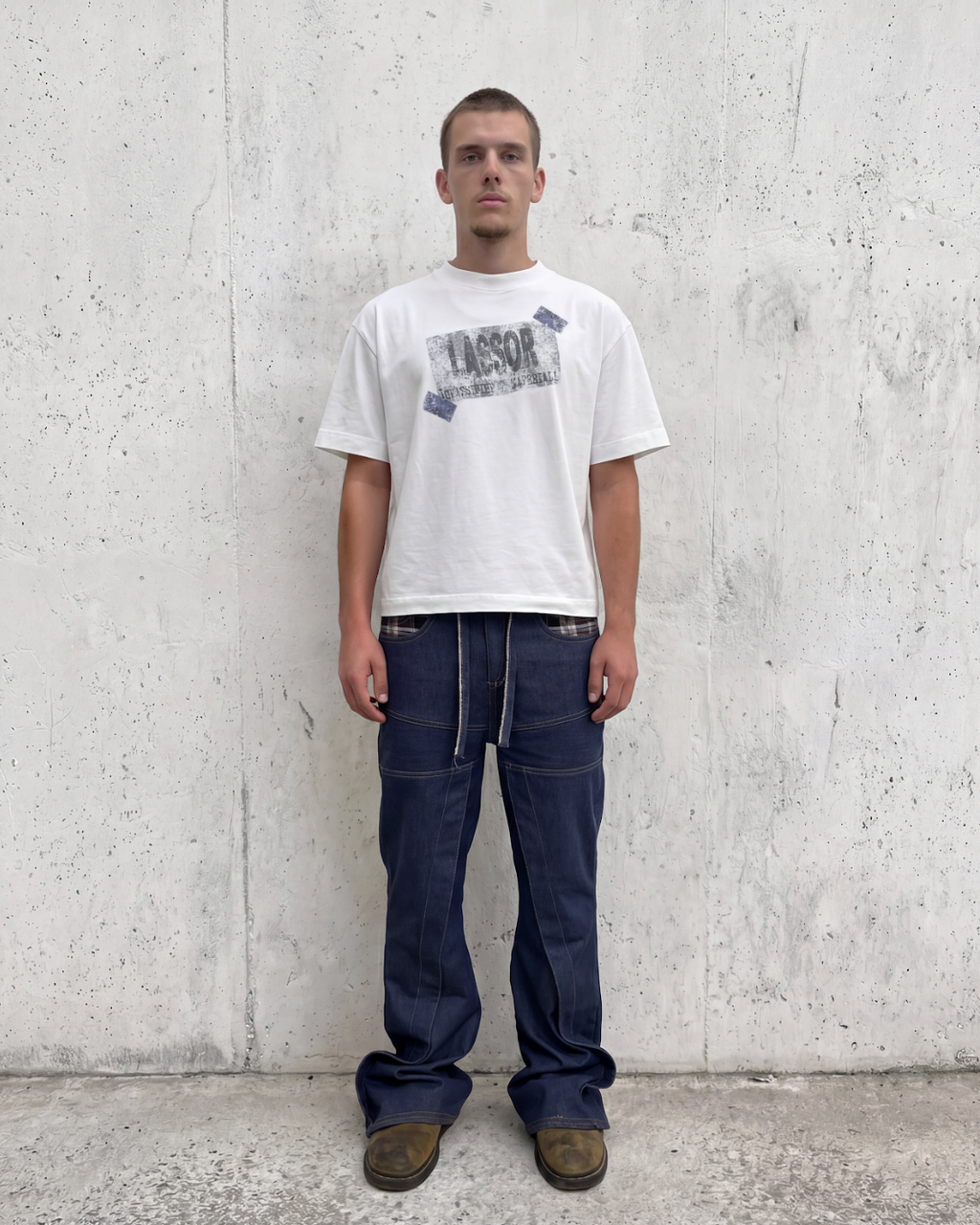 Modelo con camiseta blanca Classified Material y vaqueros